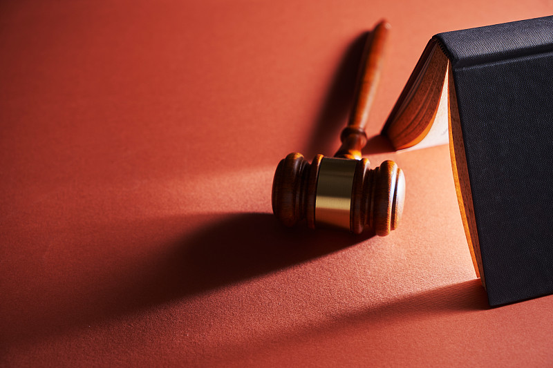 红色背景下的法槌、锤子和法律书籍，马来西亚图片下载