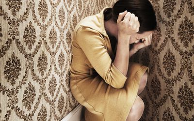 woman having an anxiety attack in the corner