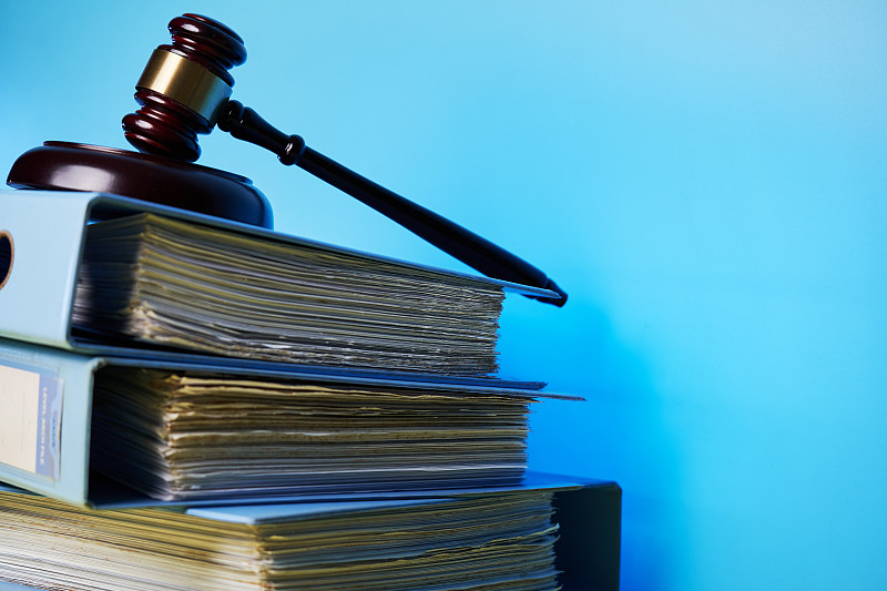 蓝色背景下桌子上法槌和书籍的特写图片下载