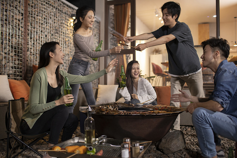 年轻朋友在庭院里烧烤聚餐图片下载