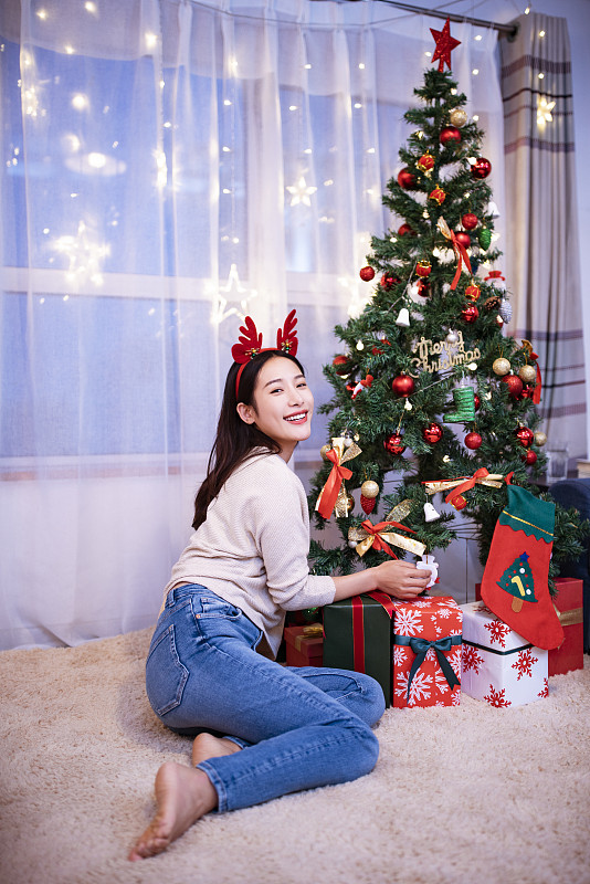 年轻女子与圣诞树图片下载