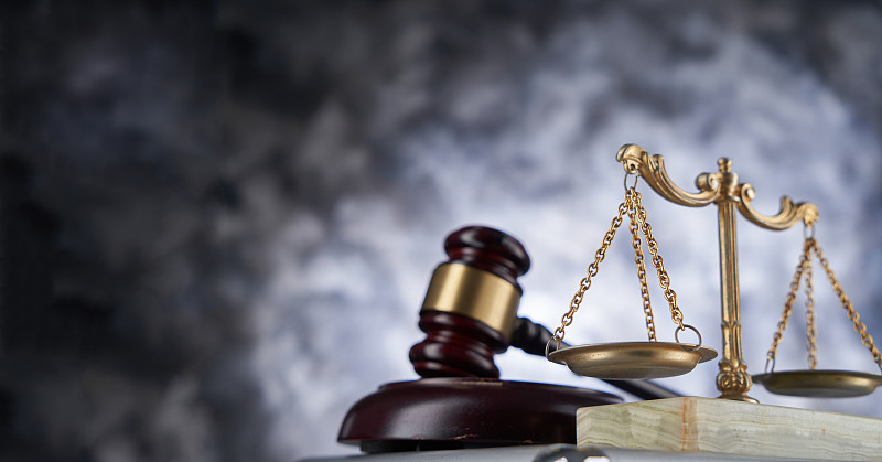 天秤和法槌在公文包上的特写，灰色背景，马来西亚图片下载