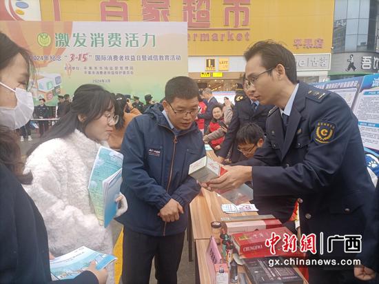 图为平果市烟草专卖执法人员为群众讲解假烟的识别技巧。丘长江 摄