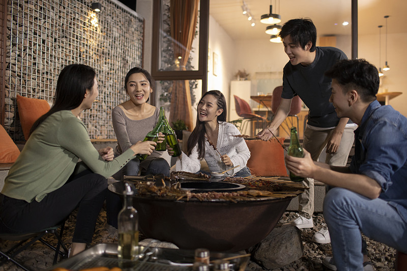 年轻朋友在庭院里烧烤聚餐图片下载