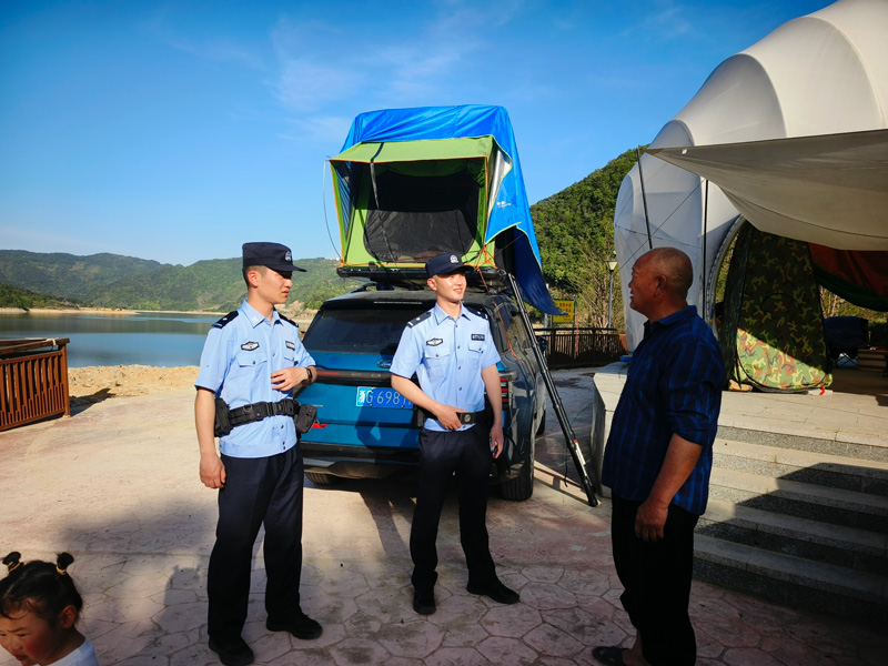 民警对露营的游客进行安全提醒。胡昌清摄