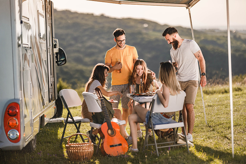 在大自然中露营,愉快的朋友们边聊边享受。图片下载