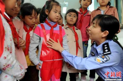 资料图:一名女警官告诉孩子们身体的哪些部位不能被随意碰触。/p中新社发 张娅子 摄