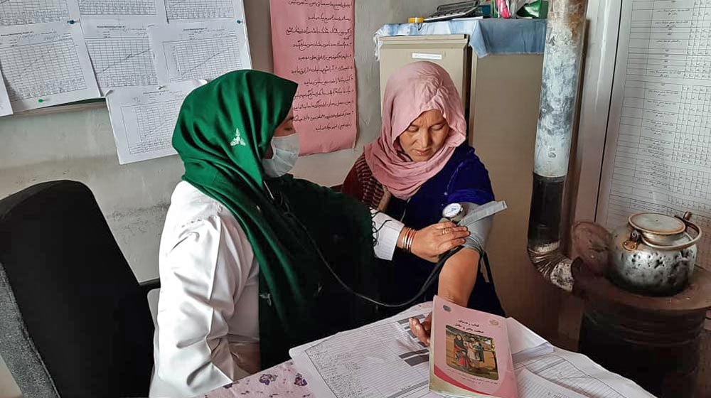 A midwife takes a woman's blood pressure at a family health house in rural Afghanistan.