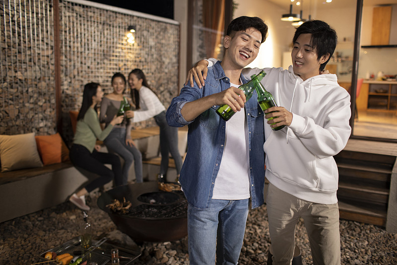 年轻朋友在庭院里烧烤聚餐图片下载