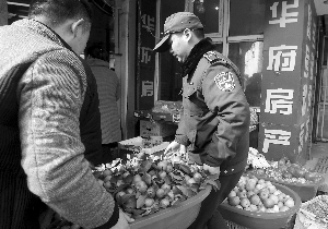 城管帮店主将占道经营的商品搬进店里 现代快报记者 顾炜 摄