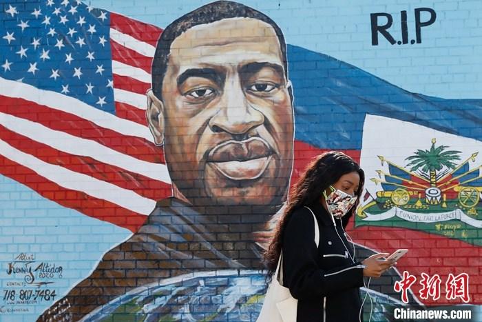 当地时间3月9日，美国纽约布鲁克林区一位市民走过弗洛伊德画像。当日，美国弗洛伊德命案“跪颈”执法前警察德里克·肖万的庭审在明尼苏达州亨内平县法院正式开始。 /p中新社记者 廖攀 摄