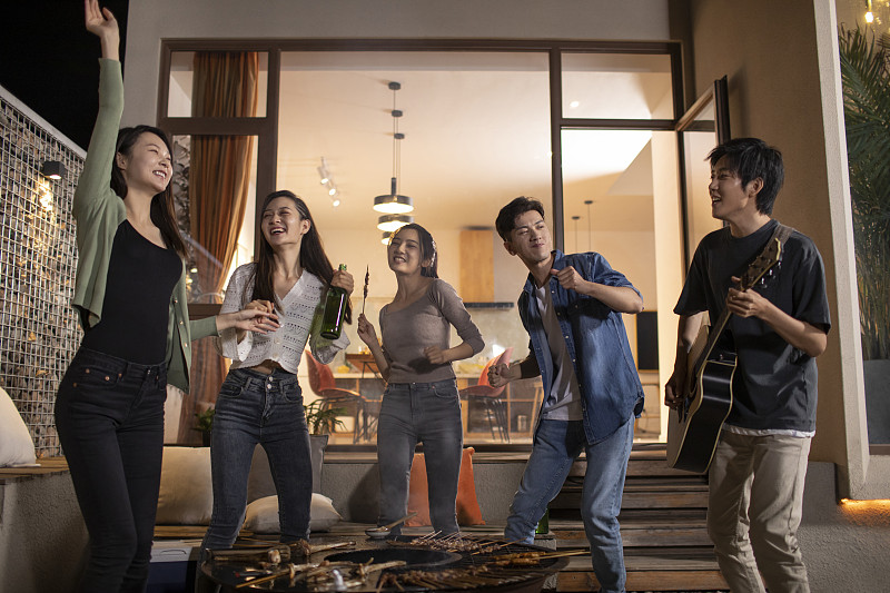 年轻朋友在庭院里烧烤聚餐图片下载