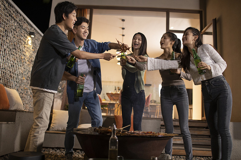 年轻朋友在庭院里烧烤聚餐图片下载