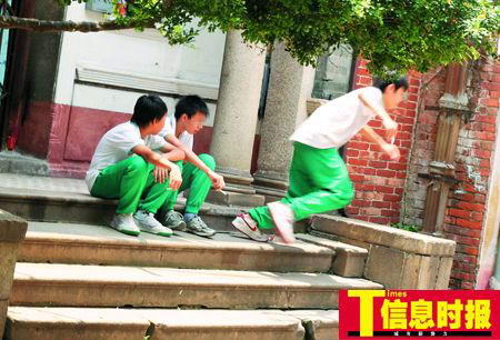 昨日，几名学生躲在一处民宅的阶梯上抽烟，一名学生见到记者拍照拔腿就逃。龙成关 何剑辉 摄