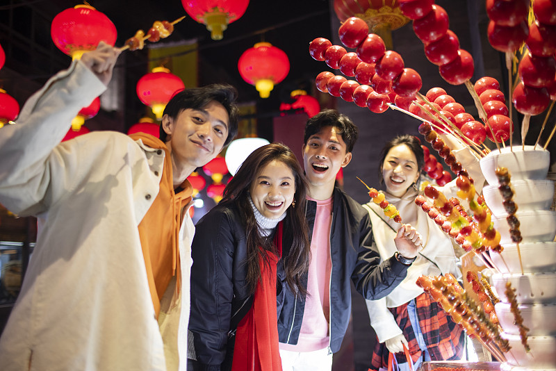 年轻朋友们逛街吃冰糖葫芦图片下载