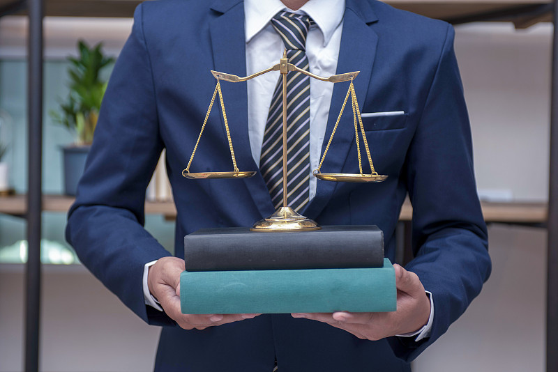 司法公正与法律概念。办公室里有黄铜天平的男律师图片下载