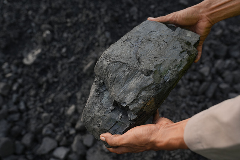 一个人拿着一块煤图片下载