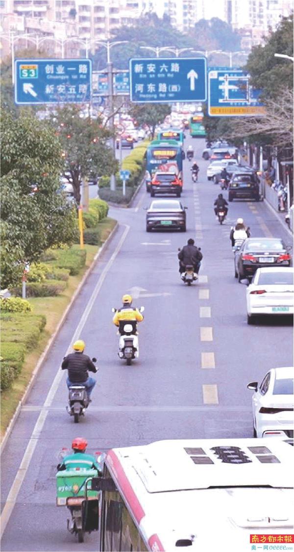 多位外卖员在机动车道左侧驾驶电动自行车。