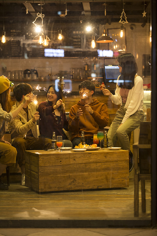 五个青年男女一起在酒吧聚会嬉戏放烟花欢度圣诞节图片下载