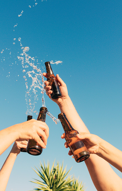 人们举起和扔瓶子的垂直镜头显示庆祝图片下载