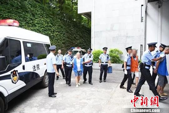 图为犯罪嫌疑人被带入法庭 桂法宣 摄